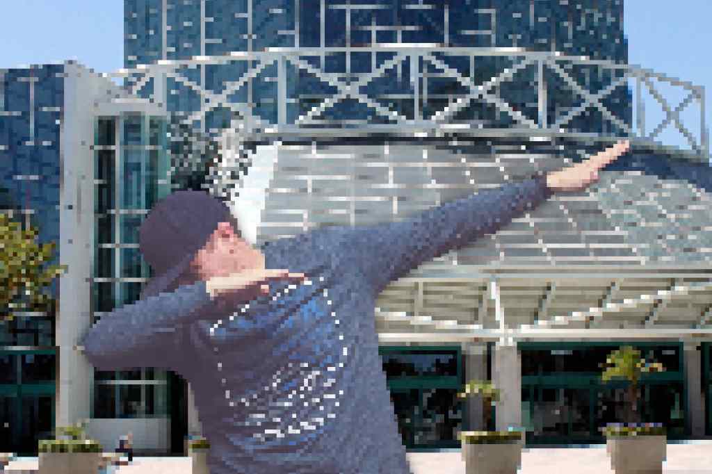 A pixelated man dabbing in front of the pixelated LA convention center.