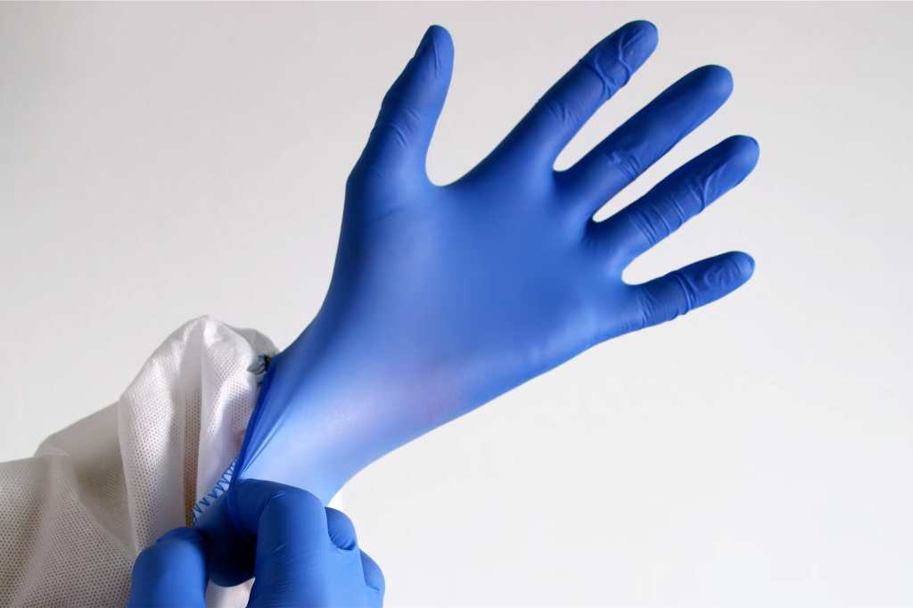 putting on a blue latex glove