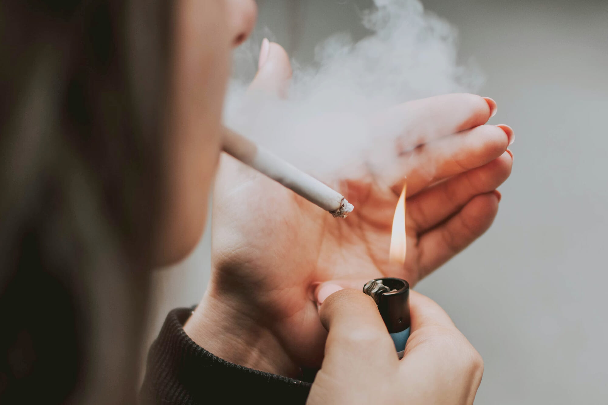 a woman lighting a cigarette